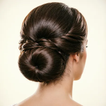 Back view of a bride with an elegant figure-eight bun, carefully folded sections creating looping shape, contemporary luxury style, soft studio lighting with clean background.