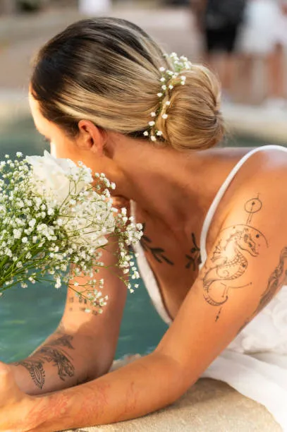 Portrait of a bride with a modern Pammy updo, effortless volume, soft texture, playful face-framing strands, intentionally relaxed, minimalist interior with soft natural light.