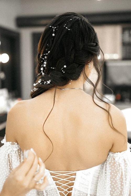 Free Rear view of a bride's elegant hairstyle adorned with floral accessories, perfect for wedding inspiration. Stock Photo